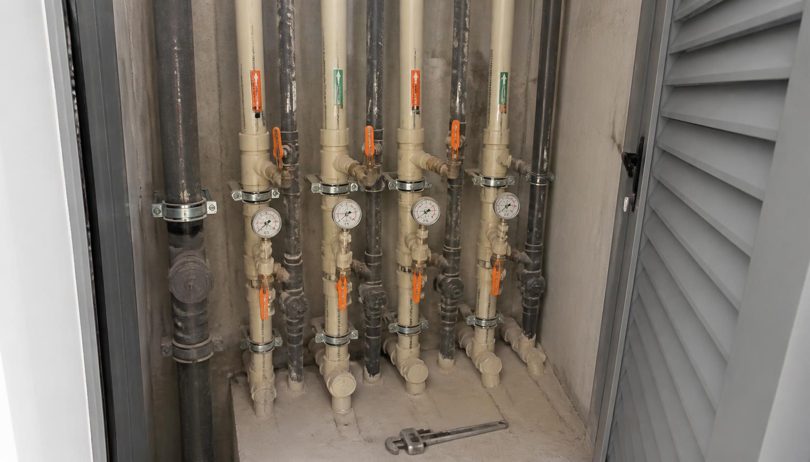Shaft técnico de prédio com prumadas hidráulicas novas, registros e manômetros instalados